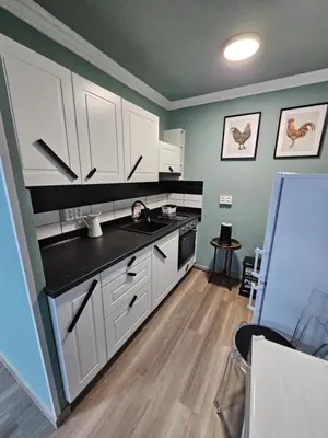 a kitchen with white cabinets and a black counter top at Westfield apartment in Prague