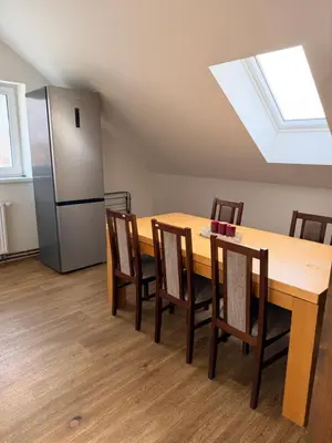 a kitchen with a table and chairs and a refrigerator at Sleep & Go Czech Republic - Korycany in Neratovice