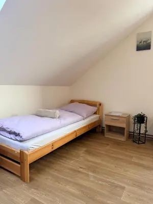 a bedroom with a bed and a side table at Sleep & Go Czech Republic - Korycany in Neratovice