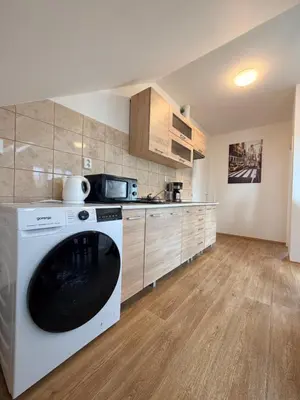 a kitchen with a washing machine in a room at Sleep & Go Czech Republic - Korycany in Neratovice