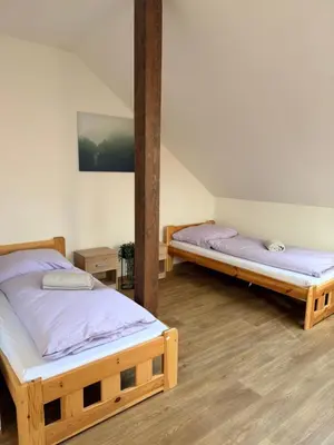 two twin beds in a room with wooden floors at Sleep & Go Czech Republic - Korycany in Neratovice