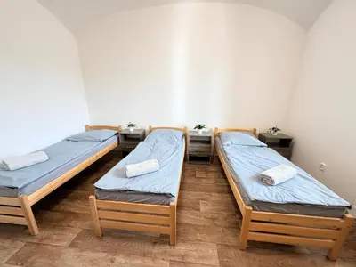 two twin beds in a room with two tables at Sleep & Go Czech Republic - Mořina in Mořina