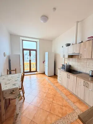 a large kitchen with a table and a refrigerator at Sleep & Go Czech Republic - Mořina in Mořina