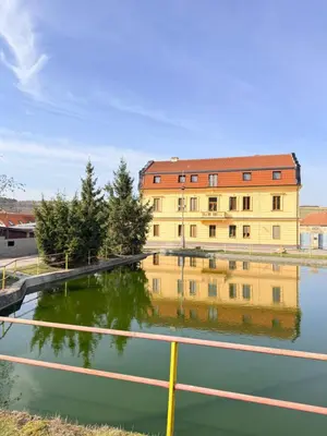 a building with its reflection in a body of water at Sleep & Go Czech Republic - Mořina in Mořina