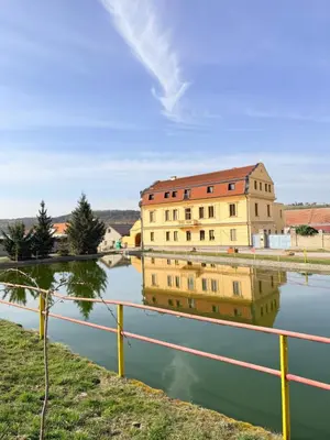 a reflection of a building in a body of water at Sleep & Go Czech Republic - Mořina in Mořina