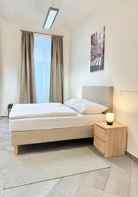 a bedroom with a large bed and a table at Sleep & Go Czech Republic - Praha 5 Anděl in Prague