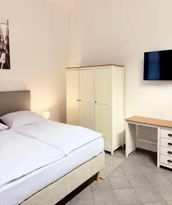 a bedroom with a bed and a desk and a television at Sleep & Go Czech Republic - Praha 5 Anděl in Prague