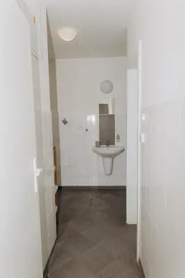 a white bathroom with a sink and a mirror at Sleep & Go Czech Republic - Praha 5 Anděl in Prague