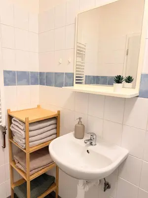 a bathroom with a sink and a mirror and towels at Sleep & Go Czech Republic - Praha 5 Anděl in Prague