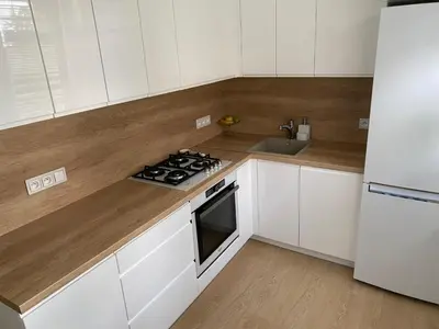 a kitchen with white cabinets and a stove and a sink at Near city center flat in Prague