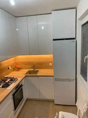 a white kitchen with a refrigerator and a sink at Near city center flat in Prague