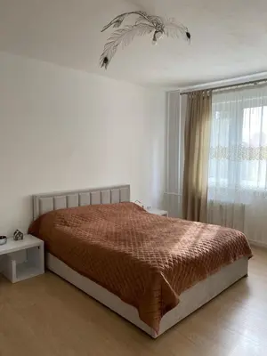 a white bedroom with a bed and a window at Near city center flat in Prague