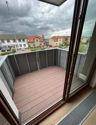 a balcony with a wooden deck with a view at Bright & Cosy 1-Bedroom Apartment with Balcony in Prague