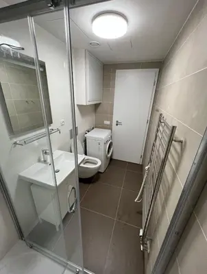 a bathroom with a toilet and a sink and a shower at Bright & Cosy 1-Bedroom Apartment with Balcony in Prague