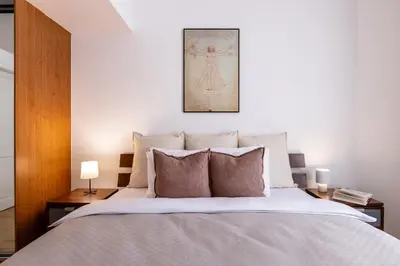 a bedroom with a large bed with two lamps at TurnKey I Old Town 5BR Loft Apartment in Prague