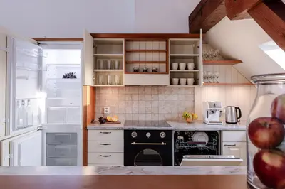 a kitchen with white cabinets and a black oven at TurnKey I Old Town 5BR Loft Apartment in Prague