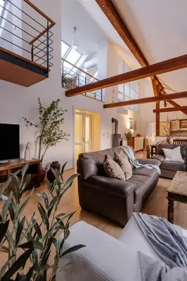 a living room with a leather couch and a tv at TurnKey I Old Town 5BR Loft Apartment in Prague