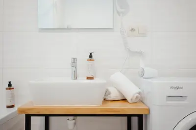 a bathroom with a white sink and a white toilet at WagnerStays 2BD Suites City Center Residence in Prague