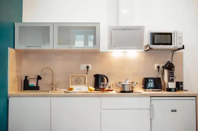 a kitchen with white cabinets and a counter top at WagnerStays 2BD Suites City Center Residence in Prague