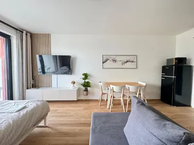 a living room with a table and a black refrigerator at Centrum Park District in Prague