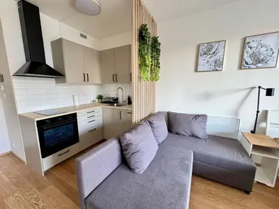 a living room with a couch and a kitchen at Centrum Park District in Prague