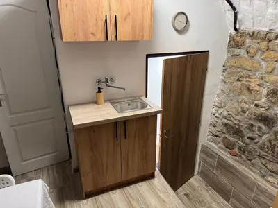 a bathroom with a sink and a stone wall at Suterénní apartmán na Hejtmánce u letiště v Mladé Boleslavi in Mladá Boleslav