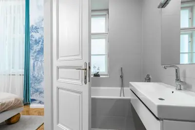 a white bathroom with a sink and a bath tub at Riverside N22 in Prague