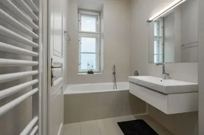 a white bathroom with a sink and a bath tub at Riverside N22 in Prague