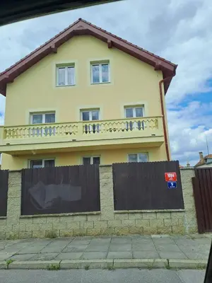 a yellow house with a fence in front of it at HaKhanhFamily in Prague