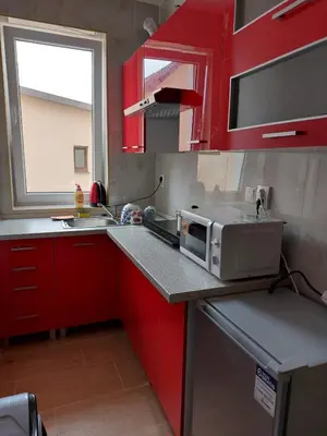a kitchen with red cabinets and a microwave on a counter at HaKhanhFamily in Prague