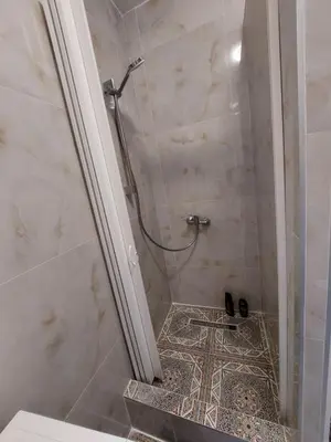a bathroom with a shower with a tile floor at HaKhanhFamily in Prague