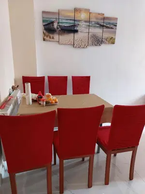 a dining room table with red chairs and a painting at HaKhanhFamily in Prague