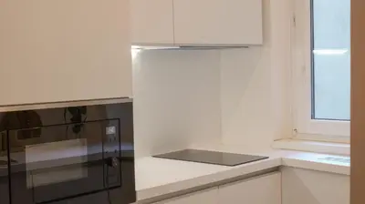 a white kitchen with a refrigerator and a window at Royal Apartment on Wenceslas Square in Prague