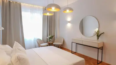 a white bedroom with a bed and a mirror at Royal Apartment on Wenceslas Square in Prague