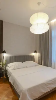 a bedroom with a large white bed and two lights at Royal Apartment on Wenceslas Square in Prague