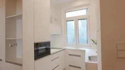 a kitchen with white cabinets and a window at Royal Apartment on Wenceslas Square in Prague
