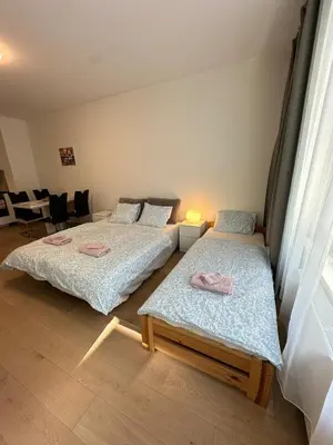 two beds in a room with a room with chairs at Diamond on Wenceslas Square in Prague