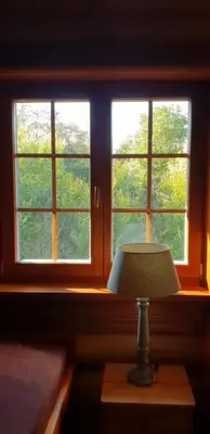 a lamp sitting on a table in front of a window at Ranči v Buši - pokoj ve srubu in Čím