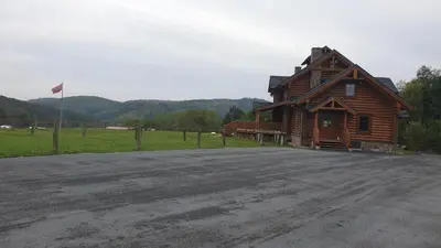 a log cabin with a flag on the side of a road at Ranči v Buši - pokoj ve srubu in Čím