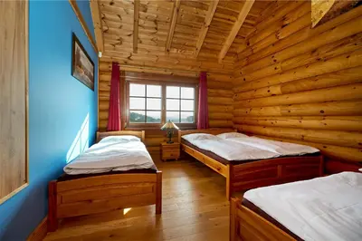 a room with two beds in a log cabin at Ranči v Buši - pokoj ve srubu in Čím