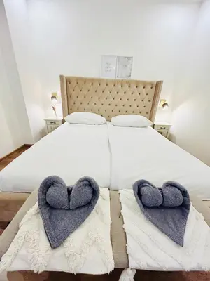 two hearts on a bed with towels on it at New luxury style apartment in central Prague in Prague