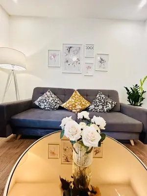 a living room with a couch and a glass table with flowers at New luxury style apartment in central Prague in Prague