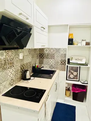 a kitchen with white cabinets and a black counter top at New luxury style apartment in central Prague in Prague