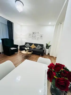 a living room with a couch and a table with roses at New luxury style apartment in central Prague in Prague