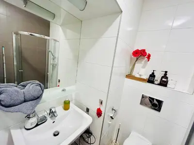 a white bathroom with a sink and a mirror at Luxury and cozy apartment Vinohrady Prague in Prague