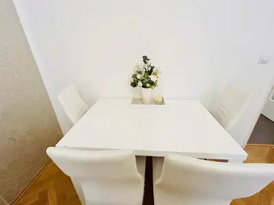 a white table with white chairs and a vase with flowers at Luxury and cozy apartment Vinohrady Prague in Prague