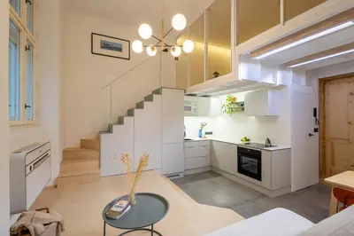 a living room with a staircase and a table at Rentero Designer Petite Stay, Prague in Prague