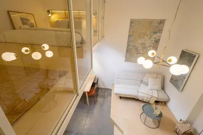 a living room with a white couch and a window at Rentero Designer Petite Stay, Prague in Prague