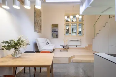 a living room with a table and a chair at Rentero Designer Petite Stay, Prague in Prague