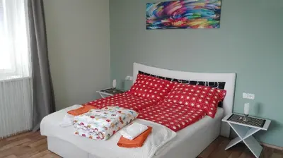 a bedroom with a bed with red and white pillows at Dreamy Apartment in Prague